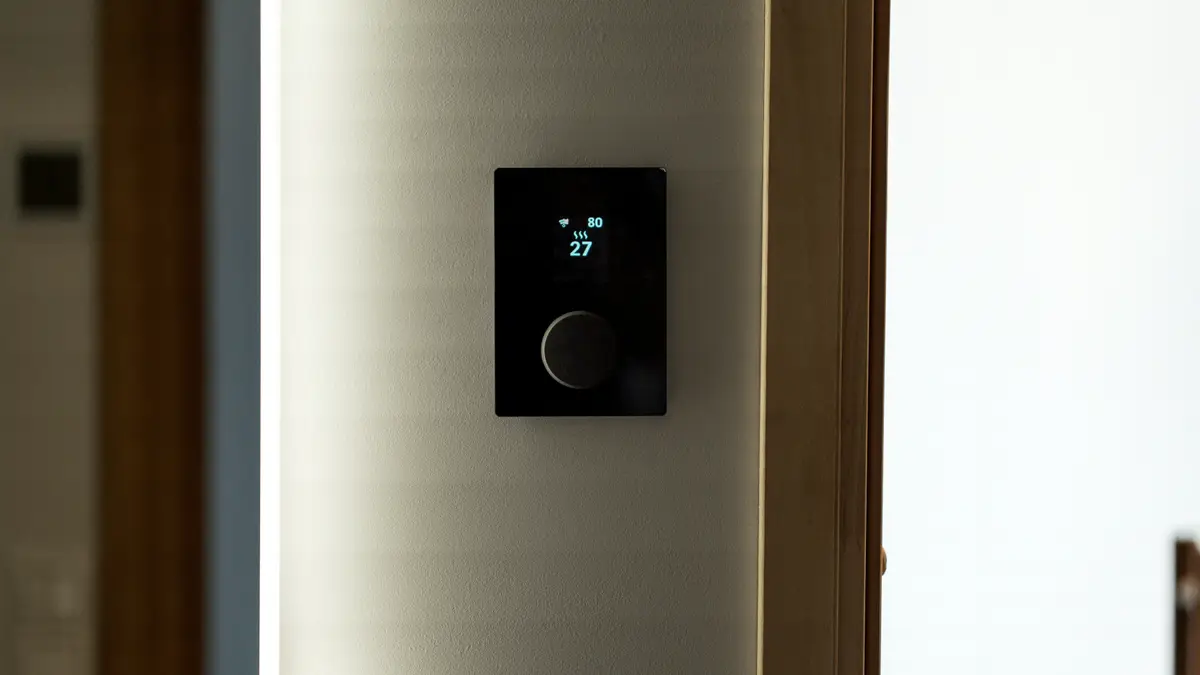ترموستات هوشمند مشکی نصبشده روی دیوار برای کنترل خانه هوشمند